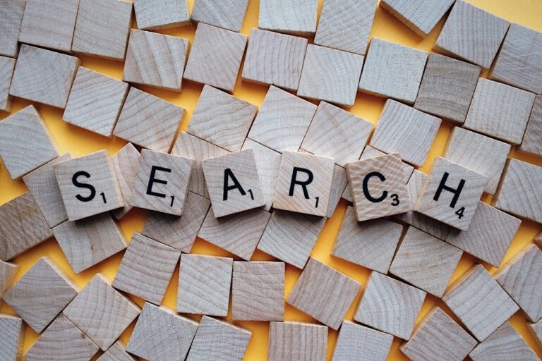 A pile of scrabble letters that spell out the word "SEARCH."